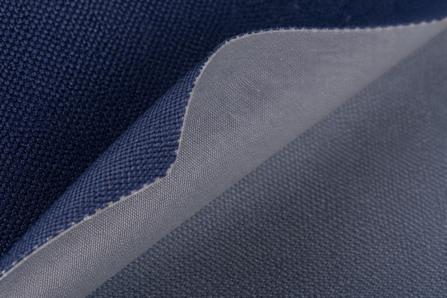close-up of the PU coating layer peeling at the edge of navy oxford fabric
