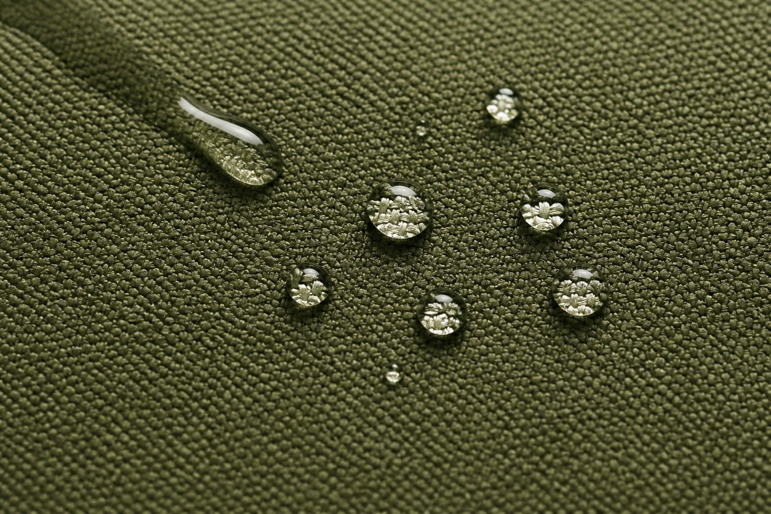 water droplets beading and rolling on waterproof-coated olive oxford fabric